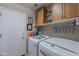 Clean laundry room with white washer and dryer and wall-mounted cabinets at 9642 E Irwin Ave, Mesa, AZ 85209