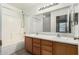 Bathroom featuring a double sink vanity, shower-tub combo, and large mirror at 9704 W Cordes Rd, Tolleson, AZ 85353