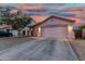 One story home with a two-car garage and low maintenance landscaping at dusk at 9704 W Cordes Rd, Tolleson, AZ 85353