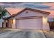 One story home with a two-car garage and low maintenance landscaping at dusk at 9704 W Cordes Rd, Tolleson, AZ 85353