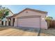 View of the home's two-car garage with decorative architectural design and private drive at 9704 W Cordes Rd, Tolleson, AZ 85353