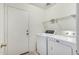 Functional laundry room with a washer, dryer, shelving and access door at 9704 W Cordes Rd, Tolleson, AZ 85353