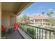 Balcony overlooking community pool featuring metal railing and red patio furniture at 9711 E Mountain View Rd # 2543, Scottsdale, AZ 85258