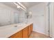 Bright bathroom featuring double sinks with wood cabinets and a large mirror with vanity lighting at 16036 N 11Th Ave # 1084, Phoenix, AZ 85023