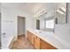 Bright bathroom with dual sinks, a large mirror, and updated lighting at 16036 N 11Th Ave # 1084, Phoenix, AZ 85023