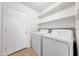 Well-lit laundry area featuring white appliances, shelving, and tile flooring at 16036 N 11Th Ave # 1084, Phoenix, AZ 85023