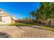 Spacious backyard featuring artificial turf, a desert landscape, and a large brick-paved patio area at 1779 E Kaibab Dr, Chandler, AZ 85249