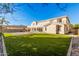 Expansive backyard with a large grassy area and a view of the home's exterior featuring large glass windows at 1779 E Kaibab Dr, Chandler, AZ 85249