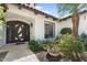 A home's inviting entry with a custom wrought iron door, tiled walkway, and vibrant potted plants at 3117 E Maryland Ave, Phoenix, AZ 85016