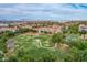 This photo shows an aerial view of a park in the neighborhood with green grass, trees, a walking path and the city skyline at 4615 E Calistoga Dr, Gilbert, AZ 85297