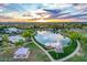 Panoramic aerial shot capturing the community's pond, recreational facilities, and green spaces under a vibrant sunset sky at 4615 E Calistoga Dr, Gilbert, AZ 85297