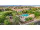 Aerial view of a large community pool and surrounding lounge area, with a playground nearby surrounded by mature trees at 4615 E Calistoga Dr, Gilbert, AZ 85297