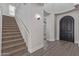 Elegant entryway with hardwood floors, a carpeted staircase, and a dark door that matches the dark wood floors at 4615 E Calistoga Dr, Gilbert, AZ 85297