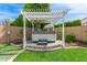 Outdoor hot tub featuring a pergola, stone base, lush landscaping and privacy fence at 4615 E Calistoga Dr, Gilbert, AZ 85297