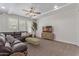 Cozy living room featuring coffered ceilings, a leather sofa, and a ceiling fan at 4615 E Calistoga Dr, Gilbert, AZ 85297