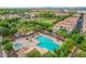 Aerial view of the community pool and lounge area, surrounded by mature trees, palm trees and well-maintained landscaping at 4615 E Calistoga Dr, Gilbert, AZ 85297