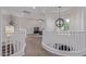 Upstairs landing with a view of the living room, a stylish light fixture, and white bannister at 4615 E Calistoga Dr, Gilbert, AZ 85297