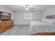 Comfortable bedroom featuring a ceiling fan, window with shutters, tv, dresser, and gray carpet at 10417 W Pioneer St, Tolleson, AZ 85353