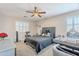Charming bedroom with a gray bed, desk with vanity mirror, ceiling fan, and window with shutters at 10417 W Pioneer St, Tolleson, AZ 85353