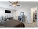 Comfortable bedroom with a brown bed, ceiling fan, desk, and walk in closet at 10417 W Pioneer St, Tolleson, AZ 85353