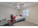 Cozy bedroom with a bed, desk, and computer gaming chair with a ceiling fan at 10417 W Pioneer St, Tolleson, AZ 85353