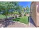 Spacious backyard with artificial turf and desert landscaping that backs up to a green space at 11060 E Sorpresa Ave, Mesa, AZ 85212