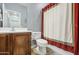 Bathroom featuring vanity with framed mirror, shower with red curtain, and standard toilet at 11060 E Sorpresa Ave, Mesa, AZ 85212
