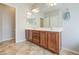 Bathroom with double vanity, white sinks, warm brown cabinets, and tile flooring at 11060 E Sorpresa Ave, Mesa, AZ 85212