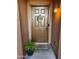 Inviting front door with a 'Welcome' wreath, accent lighting, and a potted plant at 11060 E Sorpresa Ave, Mesa, AZ 85212