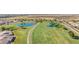 An aerial view of lush golf course with serene ponds surrounded by green grass and walking paths near residential houses at 11250 E Kilarea Ave # 276, Mesa, AZ 85209