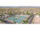 Aerial view showcases the tennis courts, clubhouse, and nearby neighborhood with mature trees and city views at 11250 E Kilarea Ave # 276, Mesa, AZ 85209