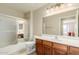 Bathroom features a vanity with wood cabinets, a large mirror, and a shower-tub combo with sliding doors at 11250 E Kilarea Ave # 276, Mesa, AZ 85209