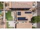 An overhead view of backyards that feature putting greens, a pool, solar panels, and shade at 13434 W Rovey Ave, Litchfield Park, AZ 85340