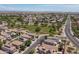 This aerial view shows a lush green park surrounded by homes and a busy road at 13434 W Rovey Ave, Litchfield Park, AZ 85340
