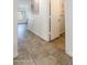 Hallway featuring tiled floors, white walls, and natural light at 13434 W Rovey Ave, Litchfield Park, AZ 85340