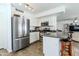Well-lit kitchen with stainless steel appliances and breakfast bar at 13434 W Rovey Ave, Litchfield Park, AZ 85340