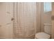 Cozy bathroom featuring a toilet, shower with curtain, and ample lighting, all well-maintained at 14897 W Valentine St, Surprise, AZ 85379