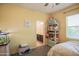 Bright bedroom features a ceiling fan, soft yellow walls, and ensuite bathroom access at 14897 W Valentine St, Surprise, AZ 85379