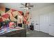 This playful bedroom features ceiling fan, vibrant decor, and an ensuite bathroom at 14897 W Valentine St, Surprise, AZ 85379