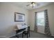 This is a bedroom with a window with patterned curtains and a drawing table at 14897 W Valentine St, Surprise, AZ 85379
