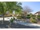 Attractive home featuring a landscaped front yard with mature trees and shrubs, plus a long driveway at 14897 W Valentine St, Surprise, AZ 85379