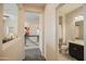 Hallway with view to bathroom with granite counters, dark wood cabinets, and tile floors at 14897 W Valentine St, Surprise, AZ 85379