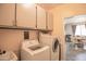 Functional laundry room with overhead cabinets and modern appliances, adjacent to the dining area at 14897 W Valentine St, Surprise, AZ 85379