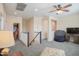 Spacious, carpeted living room featuring a ceiling fan and a staircase to another level at 14897 W Valentine St, Surprise, AZ 85379