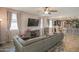 Open-concept living room with a stylish gray sofa, connecting seamlessly to the kitchen and dining area at 14897 W Valentine St, Surprise, AZ 85379
