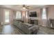Inviting living room with a comfortable gray sofa, dark wood floors, and neutral decor at 14897 W Valentine St, Surprise, AZ 85379
