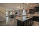 Open concept floor plan with kitchen island leading into the living area with gray sofa at 14897 W Valentine St, Surprise, AZ 85379