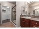 Bathroom featuring a tiled shower, a vanity with sink, and a walk-in closet at 15225 N 100Th St # 1209, Scottsdale, AZ 85260