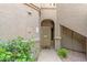 Front entrance with an arched entryway and a secure gate, and green foliage at 15225 N 100Th St # 1209, Scottsdale, AZ 85260