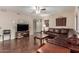 Open-concept living room with ceiling fan, hardwood floors, and comfortable leather sofa at 15225 N 100Th St # 1209, Scottsdale, AZ 85260